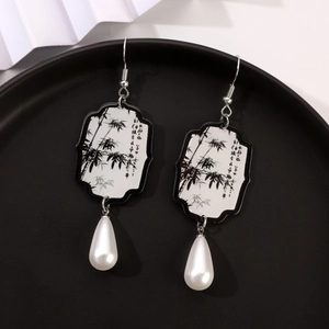 Detailed shot of folding fan earrings with ink bamboo pattern and pearl teardrop