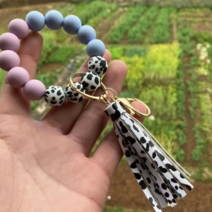 Detail of colorful silicone beaded bracelet with cow print leather tassel and metal clasp