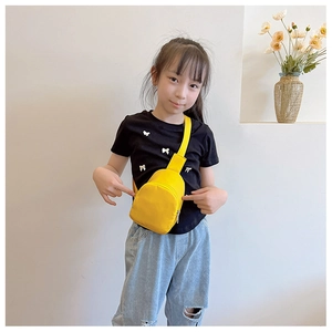 Close-up of a stylish yellow kids' crossbody chest bag worn by a young model