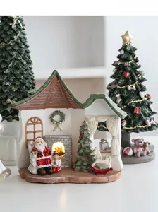 Detail of resin Christmas house ornament featuring Santa and warm glowing fireplace