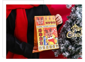 Close-up of yellow Christmas paper gift bag with reindeer print and festive greeting