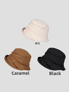 Detailed view of frayed seam bucket hats in off-white, caramel, and black cotton