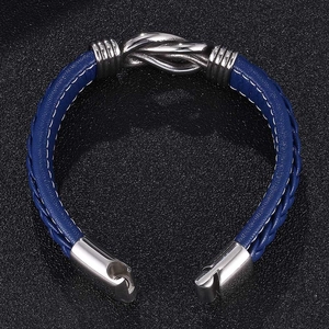 Detail of blue braided leather bracelet with white stitching and silver magnetic clasp