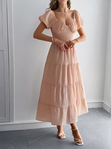 Abito rosa con maniche a sbuffo, scollo a cuore e gonna a balze su modella
