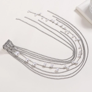 Détail de pince à cheveux argentée avec pampilles en strass et perles blanches élégantes