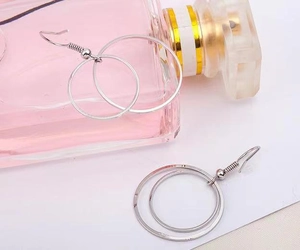 Detailed view of silver double circle drop earrings placed on a clean white surface
