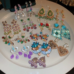 Detailed close-up of vintage heart and flower earrings with colorful zircon and pearls