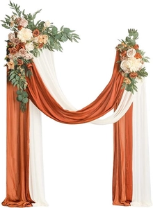 Detail of caramel and white chiffon wedding arch drapes with artificial roses and greenery