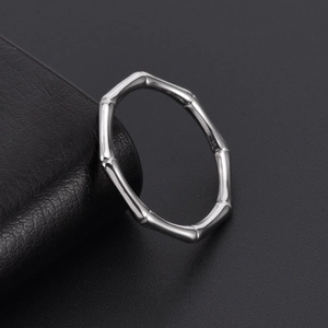 Minimalist silver bamboo joint ring in polished titanium steel on a dark leather stand