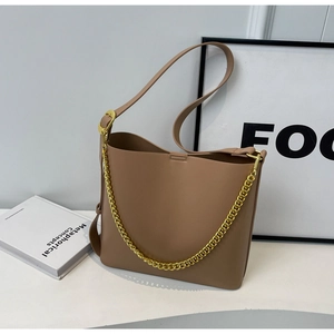 Brown bucket bag detail with textured leather surface and stylish gold chain strap