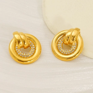 Boucles d'oreilles créoles dorées avec strass pavés sur fond de soie texturée