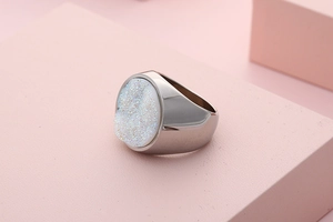 Detail shot of a round white druzy stone inlay on a wide stainless steel ring