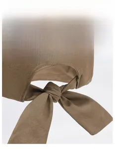 Detail of adjustable bow tie closure on brown cotton sun hat for customized fit