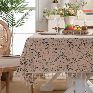 Detail view of vintage blue floral linen tablecloth with decorative tassel fringes