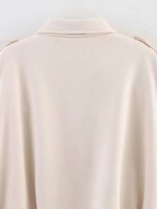 Close-up of beige bomber jacket collar and shoulder strap detail with twill texture