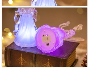 Detail of crystal acrylic angel night light showing purple LED glow and base power switch
