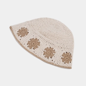 Close-up of handmade crochet bucket hat featuring intricate daisy patterns and knitted texture