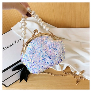 Detail of sequin shell bag with pearl handle and golden chain strap for women