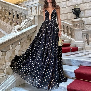 Deep V-neck black maxi dress with gold polka dots and metal ring details for luxury resort style