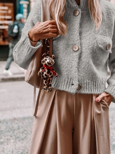 Women's grey chunky knit cardigan sweater with large buttons and casual wide-leg trousers
