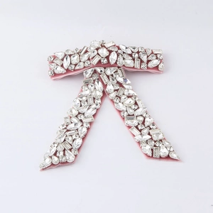 Macro detail of a pink velvet bow accessory encrusted with rhinestones and crystals