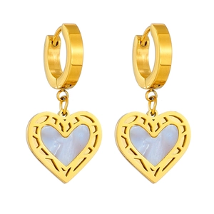 Detail of heart-shaped gold earrings with white mother-of-pearl inlay on white background