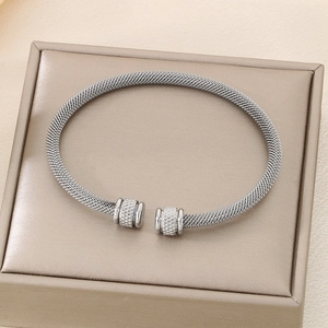 Detailed close-up of a silver mesh textured cuff bracelet with engraved cylindrical ends