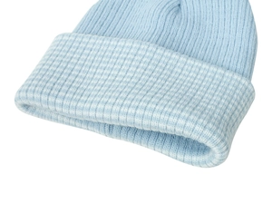 Detailed view of the light blue ribbed knit texture and folded cuff on a winter beanie