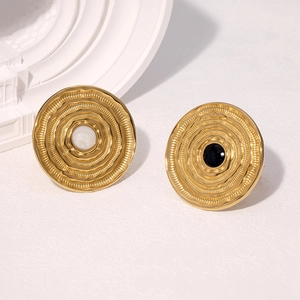 Macro shot of 18k gold plated earrings with striped concentric texture and inlaid discs