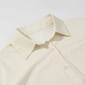 Detail view of striped beige shirt collar with delicate white lace on the pocket trim