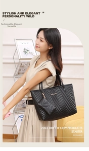 Detail of black quilted tote bag with wave embroidery and mini coin purse charm