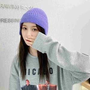 Detail of purple ribbed knit beanie showing soft wool texture and warm ear flaps