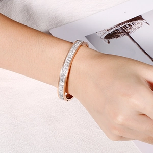 Bracelet élégant en acier titane or rose avec strass pavés sur un poignet féminin