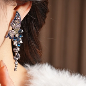 Détail de boucles d'oreilles papillon à franges et zircons colorés sur tiges argent