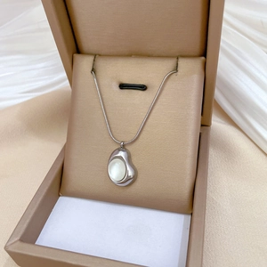 Close-up of cat eye pendant necklace with silver chain in a premium jewelry box