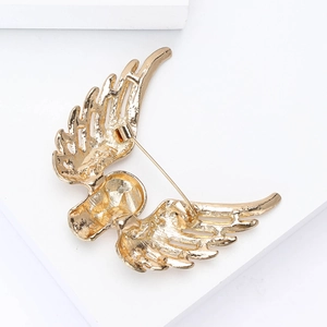 Macro view of the golden metal wing brooch back featuring a skull motif and pin fastener