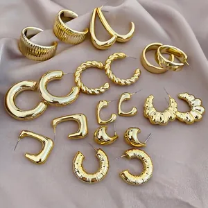 Flat lay of 20-piece gold C-shape earring set on premium champagne silk fabric
