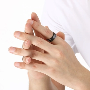 Close-up of black tungsten ring with Celtic knot patterns on a male model's finger