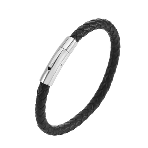 Détail du bracelet en cuir tressé noir avec boucle magnétique argentée sur fond blanc