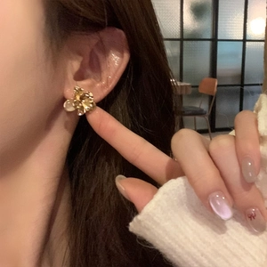 Elegant gold flower stud earrings with champagne crystals shown on a model