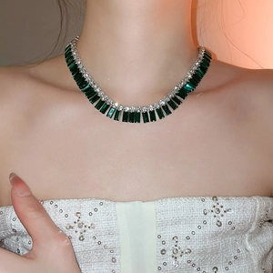Detailed view of luxury emerald cut green crystals and silver diamond tassel necklace