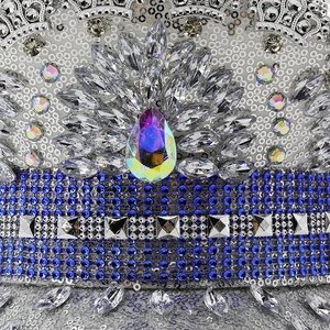 Macro shot of silver sequins with blue rhinestones and a crystal gem on the captain hat