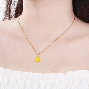 Close-up of a gold titanium steel necklace featuring a vibrant yellow pineapple pendant