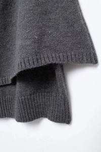 Detailed view of the dark grey knit cardigan showing precision ribbed hem craftsmanship