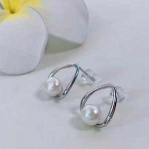Dettaglio orecchini di perle a goccia in montatura S925 argento con decorazione plumeria