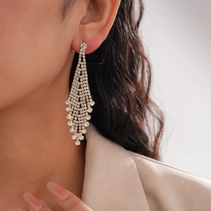 Luxurious gold drop earrings with tiered rhinestone tassels on a female model