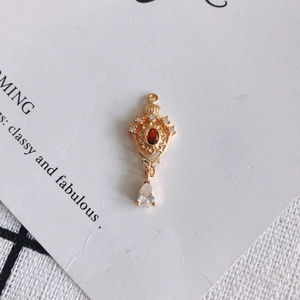 Detailansicht der 18K vergoldeten Krone mit rotem Schmuckstein und Zirkonia-Wassertropfen