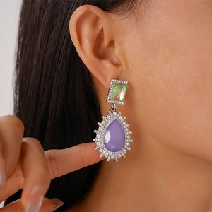 Detailed close-up of vintage earrings with green and purple water drop crystals