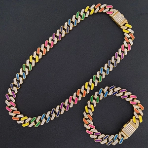 Detail of gold Cuban link chain set with colorful enamel and sparkling rhinestones
