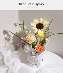 Detailed view of sunflowers and carnations in a white mini round flower gift box